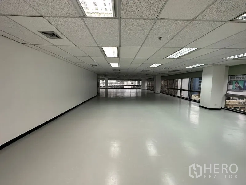 สำนักงาน ให้เช่า - พื้นที่รูปสี่เหลี่ยมลึก มีหน้าต่างปลายทั้งสองด้านและไฟฟลูออเรสเซนต์เหนือศีรษะ.