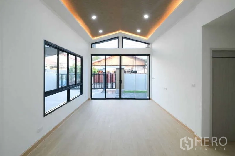 独立式住宅 出售在Bueng Kum, Bangkok - 客厅挑高人字顶天花，LED灯带，落地滑门通向前院