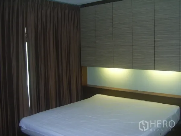 คอนโด ให้เช่าในKhlong Toei, Bangkok - ห้องนอนพร้อมตู้แขวนเหนือหัวเตียง ไฟซ่อน และผ้าม่านสูงจรดพื้น