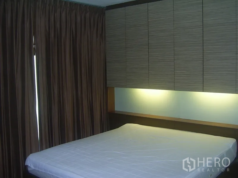 คอนโด ให้เช่าในKhlong Toei, Bangkok - ห้องนอนพร้อมตู้แขวนเหนือหัวเตียง ไฟซ่อน และผ้าม่านสูงจรดพื้น