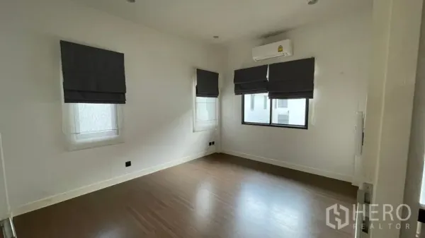 บ้าน ให้เช่าในBang Kapi, Bangkok - ห้องนอนพื้นไม้ มีเครื่องปรับอากาศ และมู่ลี่หน้าต่างสามบาน