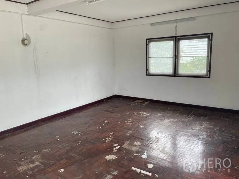 Detached House for rent in Suan Luang, Bangkok - Spacious bedroom with double windows and aged wooden floor ready for renovation.