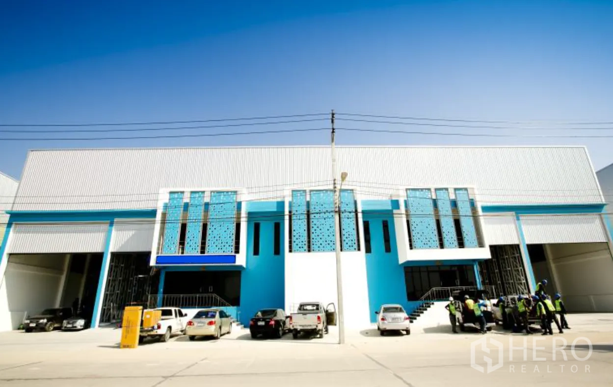 Factory for rent or sale in Bang Phli, Samut Prakan - Contemporary factory facade with tall bay entrances and perforated blue panels along the front.