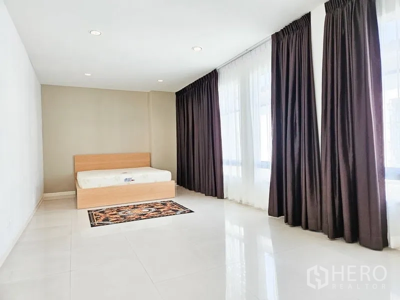 Townhouse for rent in Yan Nawa, Bangkok - Large secondary bedroom with full-height windows, blackout drapes and tiled floor.