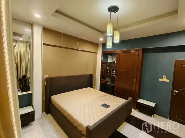 Townhouse for rent or sale in Bang Kho Laem, Bangkok - Master bedroom with upholstered bed, pendant lights and built-in wardrobe with walk-in closet.