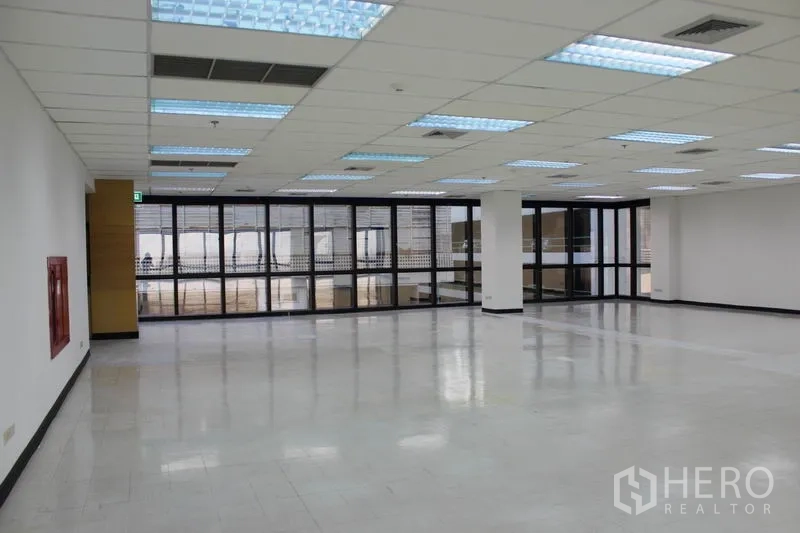 สำนักงาน ให้เช่าในWatthana, Bangkok - โถงสำนักงานกว้าง หันหน้าเข้ากระจกกรอบดำทั้งผืน แสงสว่างทั่วถึง มีป้ายทางออก