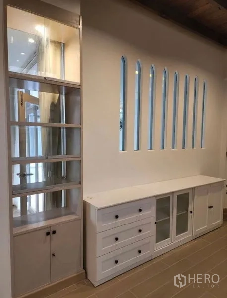 Townhouse for sale - Built-in display shelving and cabinets beside slim arched accent windows.