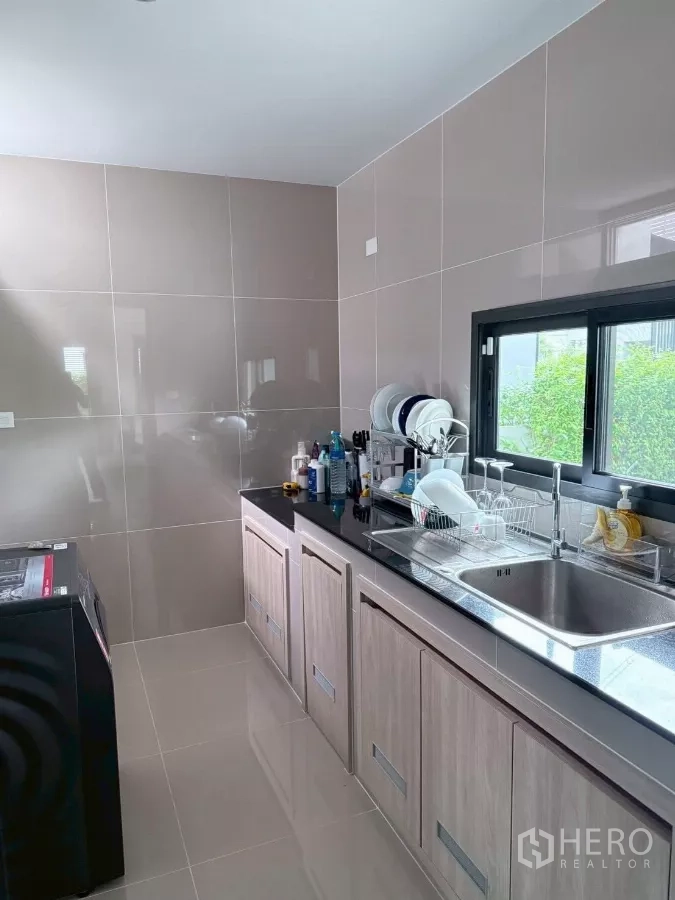 บ้าน ให้เช่าในLat Krabang, Bangkok - ครัวไทยแยก กำแพงกรุผิวกระเบื้อง เคาน์เตอร์หินสีดำ อ่างล้างจานสแตนเลส