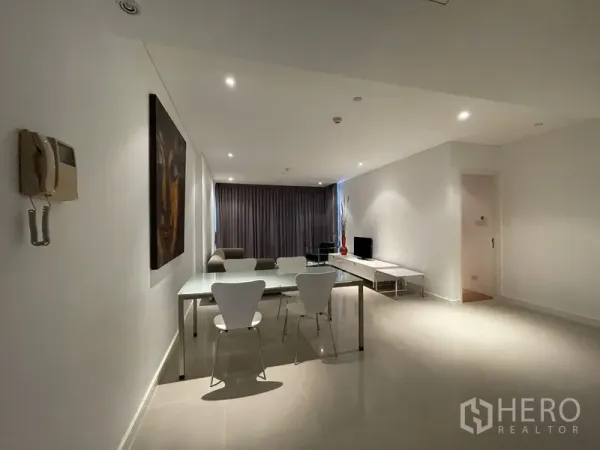 คอนโด ให้เช่าหรือขายในWatthana, Bangkok - มุมมองจากทางเข้าไปยังโซนกินข้าวและนั่งเล่น โทนมินิมอล ไฟดาวน์ไลท์ และพื้นกระเบื้องโทนกลาง.