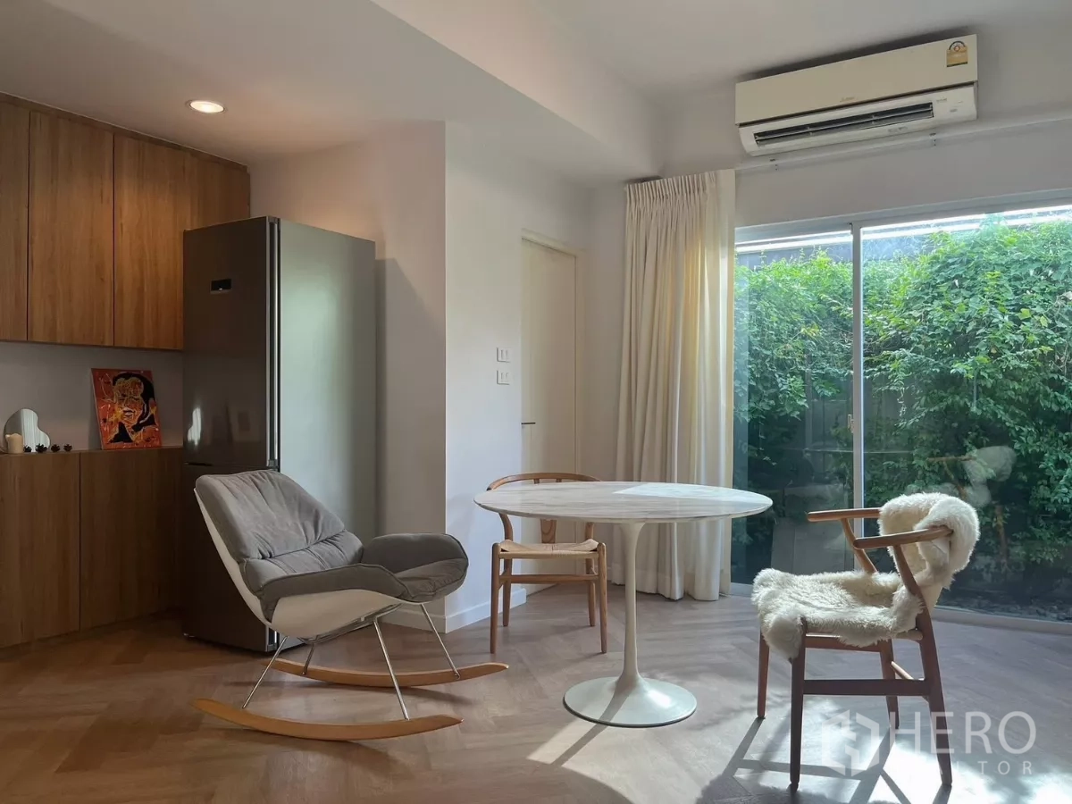 Townhouse for rent in Bang Phli, Samut Prakan - Dining nook with fridge, wood built-ins and wide glass doors to the garden.
