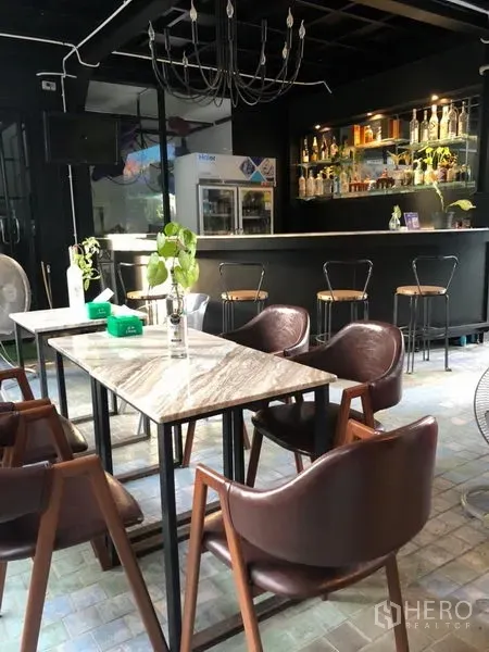 พื้นที่ขายปลีก ให้เช่าในKhlong Toei, Bangkok - บาร์ภายในพร้อมโต๊ะหินอ่อน เก้าอี้หนัง และชั้นวางขวดแบบมีไฟ