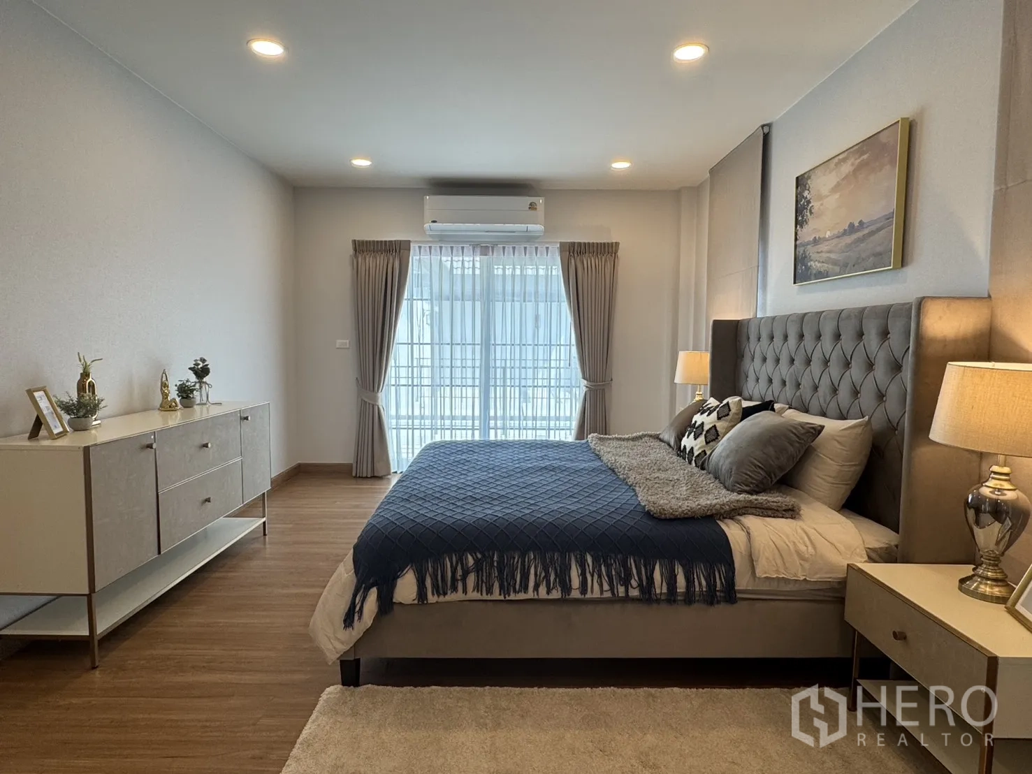 Detached House for rent in Bang Phli, Samut Prakan - Large bedroom with sideboard and sliding glass doors to a balcony, curtains and air conditioner.
