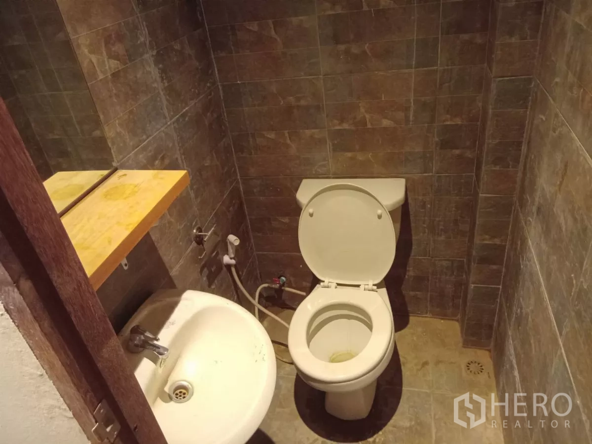 独立式住宅 出租在Phaya Thai, Bangkok - 小型卫生间，带洗手盆与置物架，棕色瓷砖。