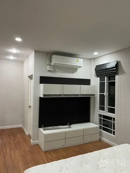 Detached House for rent in Bang Kapi, Bangkok - Bright bedroom corner with TV cabinet, split A/C and window with roman blind.