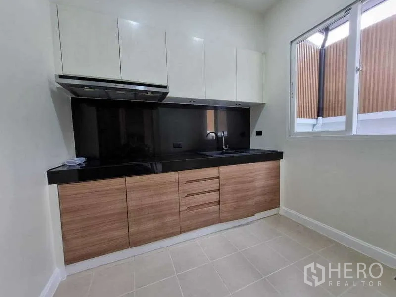 ทาวน์เฮาส์ ให้เช่าในWang Thonglang, Bangkok - ครัวบิวท์อิน เคาน์เตอร์หินสีดำ ตู้บน และหน้าต่าง