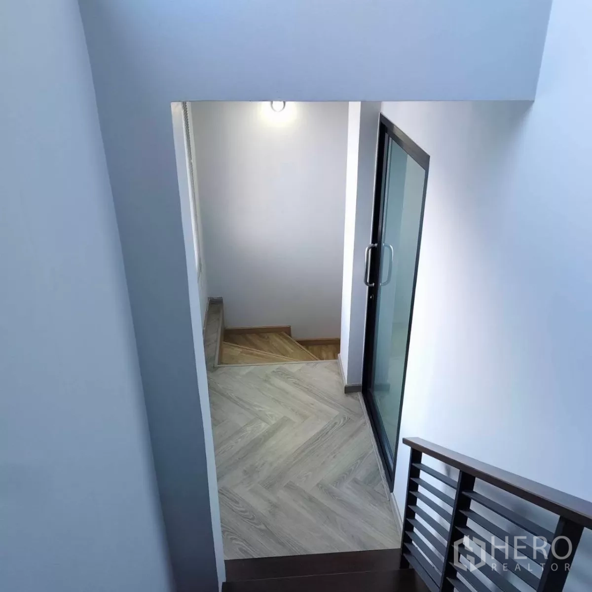 สำนักงานที่บ้าน ให้เช่าหรือขายในWatthana, Bangkok - มุมบันไดมองลงด้านล่าง มีประตูกระจกบานเลื่อนและพื้นลายไม้