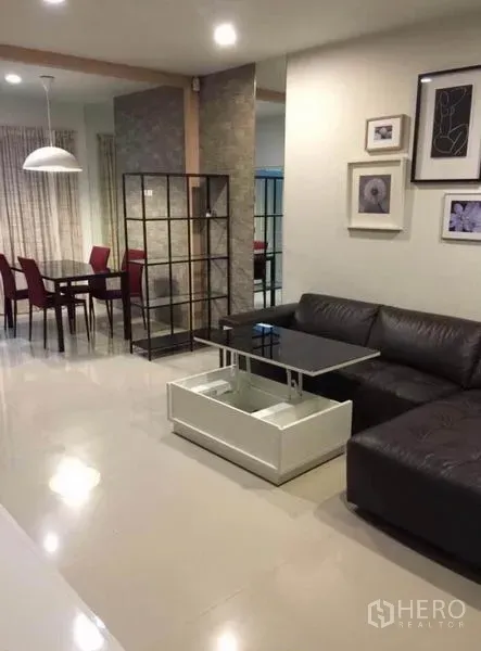 ทาวน์เฮาส์ ให้เช่าในWang Thonglang, Bangkok - พื้นที่นั่งเล่นและรับประทานอาหารแบบโอเพน พร้อมโซฟาหนัง โต๊ะกลางยกท็อป เก้าอี้ทานสีแดง และโคมไฟแขวน