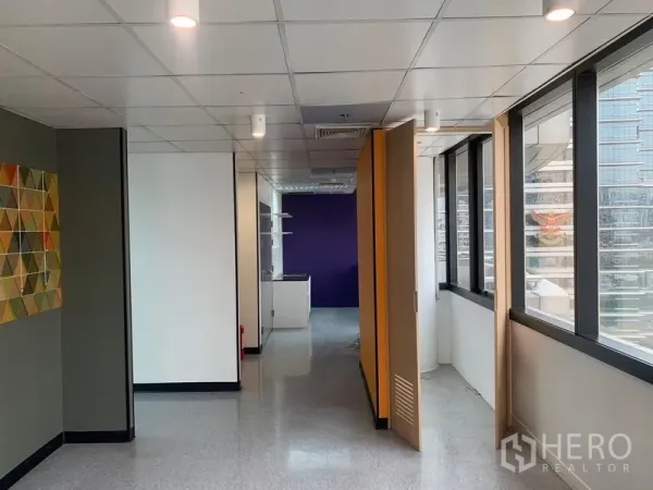 办公空间 出租在Bang Rak, Bangkok - 工作区域配折叠隔断、紫色强调墙及城市景观。