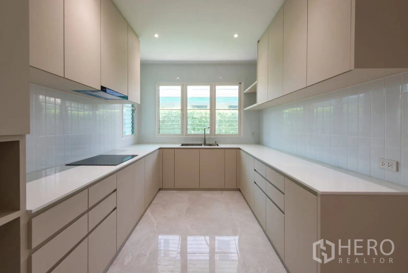 Detached House for sale in Bang Phli, Samut Prakan - Enclosed U-shaped kitchen with ample cabinets, bright windows and tiled walls.