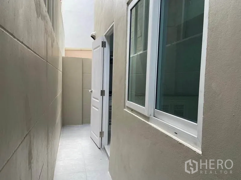 ทาวน์เฮาส์ ให้เช่าในBang Na, Bangkok - โซนซักล้างด้านข้างบ้าน ปูพื้นกระเบื้อง พร้อมหน้าต่างและประตูสีขาว