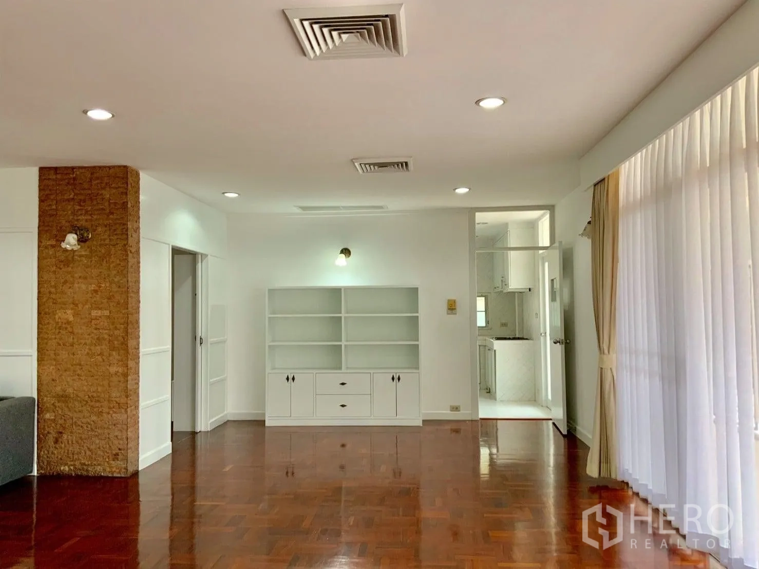 คอนโด ให้เช่าในWatthana, Bangkok - มุมห้องนั่งเล่นพร้อมตู้บิลต์อิน ไฟดาวน์ไลท์ และทางเข้าครัวสีขาว