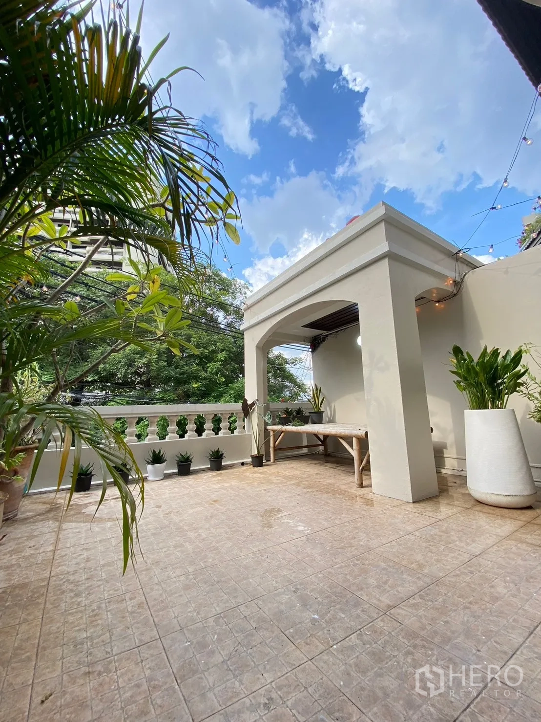 Home Office for rent in Watthana, Bangkok - Covered outdoor terrace with tiled floor, planters and open sky views.