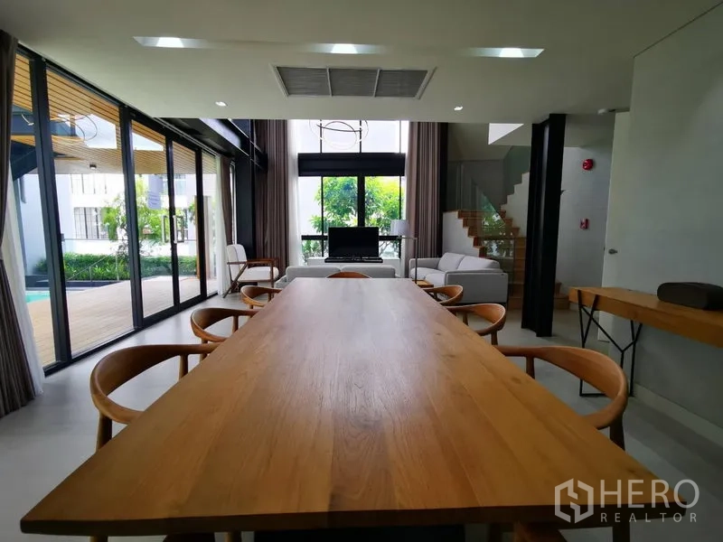 อพาร์ทเมนท์ ให้เช่าในKhlong Toei, Bangkok - พื้นที่รับประทานอาหารและนั่งเล่นแบบเปิดโล่ง โต๊ะไม้ยาว กระจกสูงจรดเพดาน มองเห็นดาดริมสระ