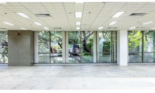 办公空间 出租在Pathum Wan, Bangkok - 采光充足的空置办公区，落地窗望向绿树，格栅吊顶与照明。
