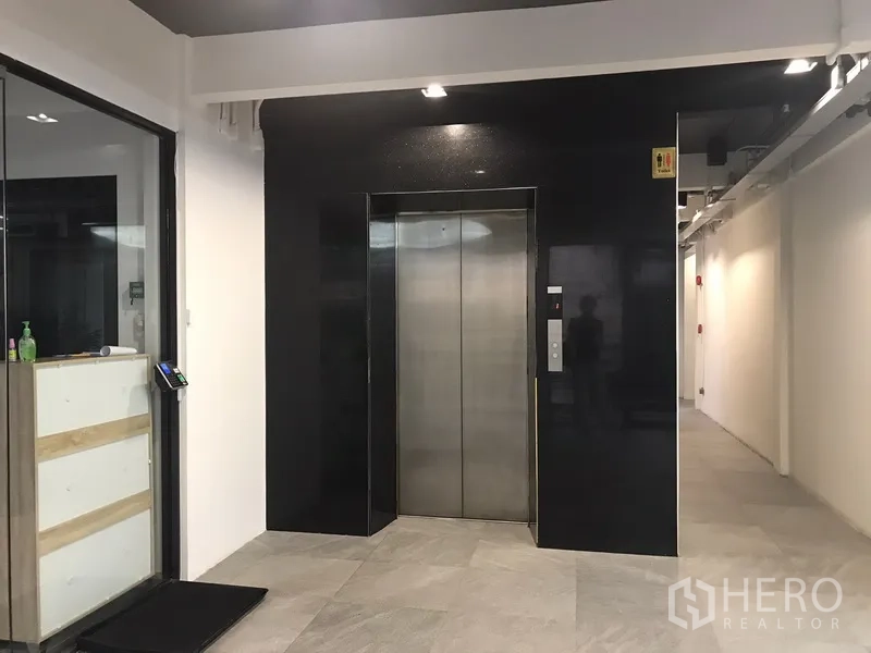 Office Space for rent in Khlong Toei, Bangkok - Modern lobby corridor with stainless-steel elevator and tiled floors.