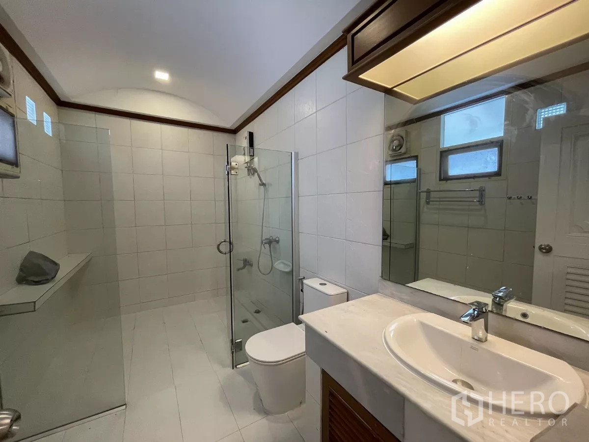 Detached House for rent in Chatuchak, Bangkok - Modern bathroom with glass shower enclosure, vanity and tiled walls.