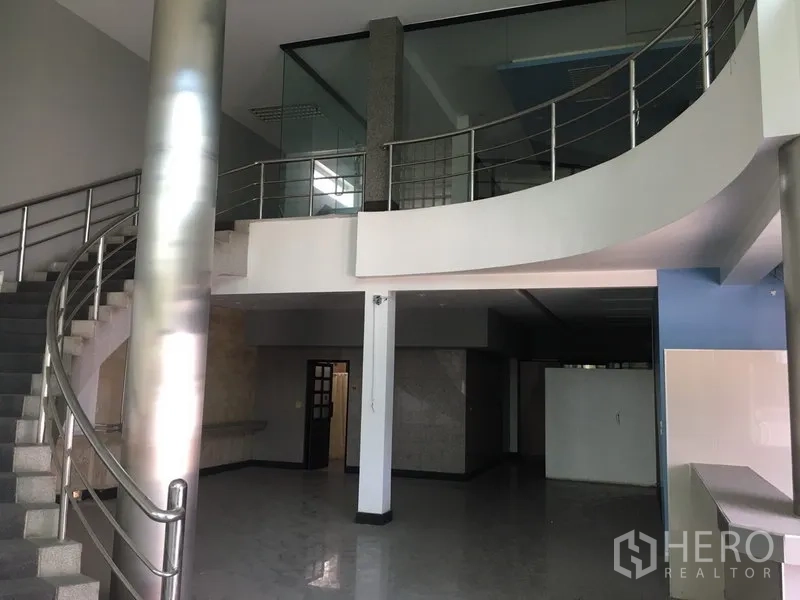 货栈 出租或出售在Bang Kapi, Bangkok - 办公楼大堂，弧形楼梯与不锈钢栏杆、瓷砖地面。