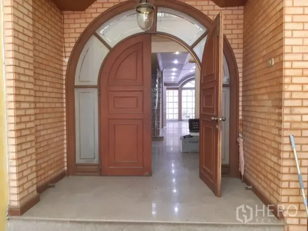 ทาวน์เฮาส์ ให้เช่าในKhlong Toei, Bangkok - ประตูไม้โค้งและเฉลียงหน้าบ้าน ผนังอิฐและโคมไฟแขวน