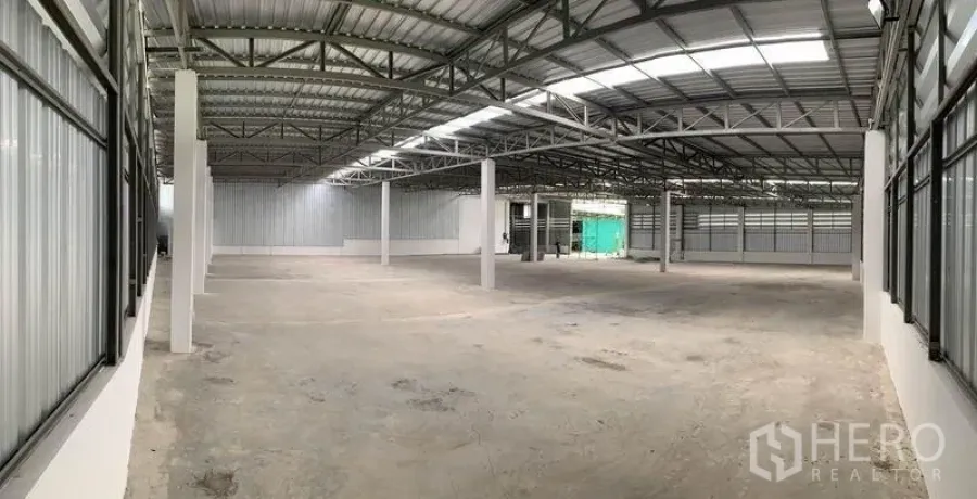 货栈 出租在Mueang Pathum Thani, Pathum Thani - 高挑开阔的仓库全景，结构立柱与金属围护清晰可见。