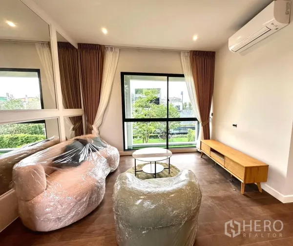 独立式住宅 出租 - 采光充足的家庭厅，大窗、空调、包膜沙发与木质电视柜