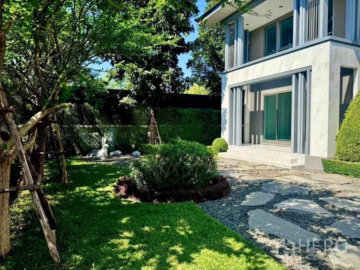 บ้าน ให้เช่าในLat Krabang, Bangkok - สวนข้างบ้านจัดแต่งต้นไม้ร่มรื่นและทางเดินหิน