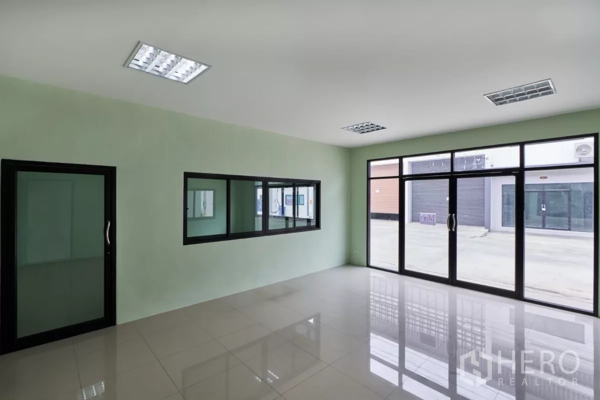 โรงงาน ให้เช่าในMueang Samut Sakhon, Samut Sakhon - ออฟฟิศชั้นล่าง หน้ากระจกเต็มบาน พื้นกระเบื้องมันวาวมองออกสู่ลานด้านหน้า.