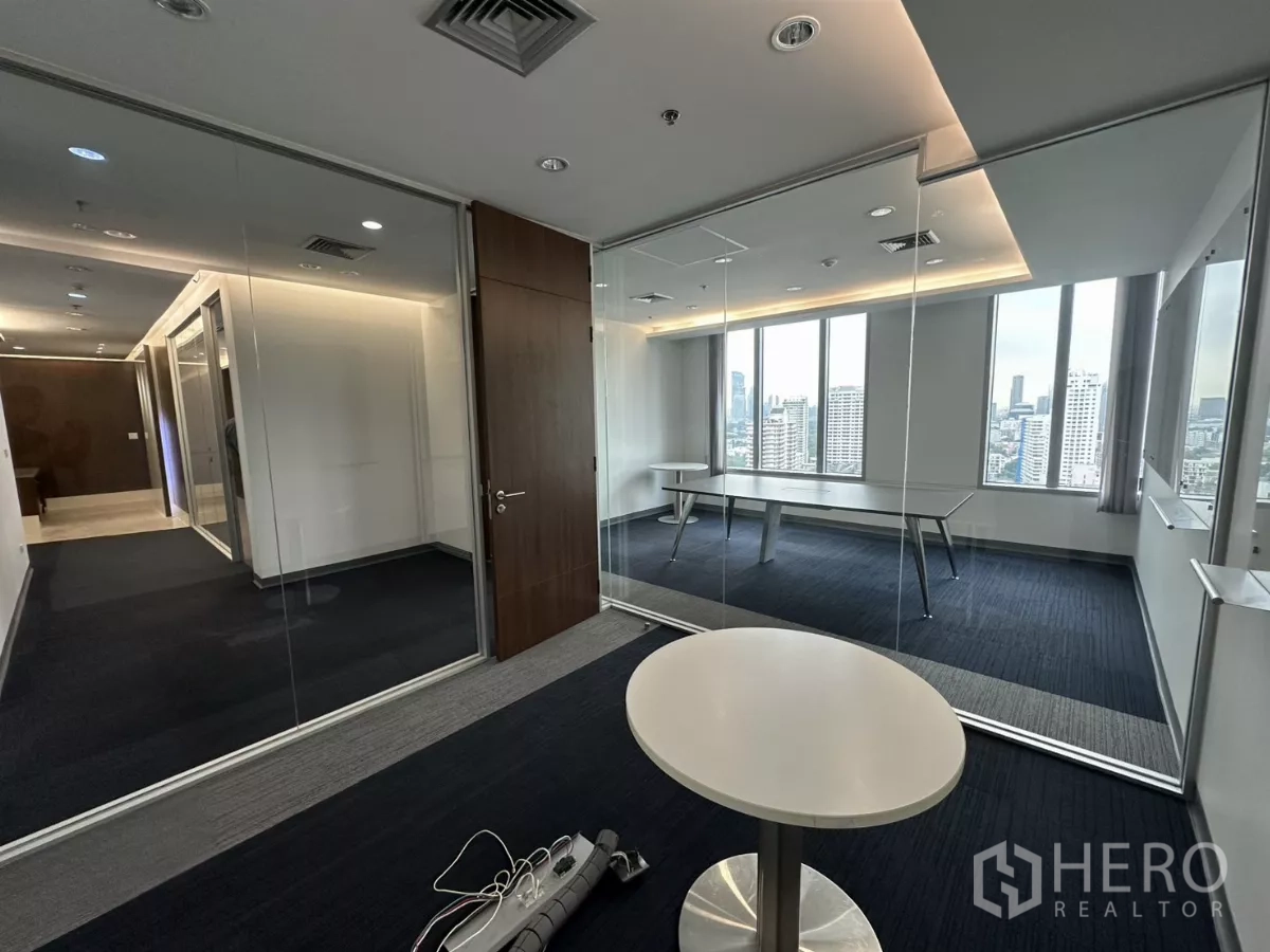 Office Space for rent in Watthana, Bangkok - Glass-walled private office opening to the corridor with city views and recessed lights.