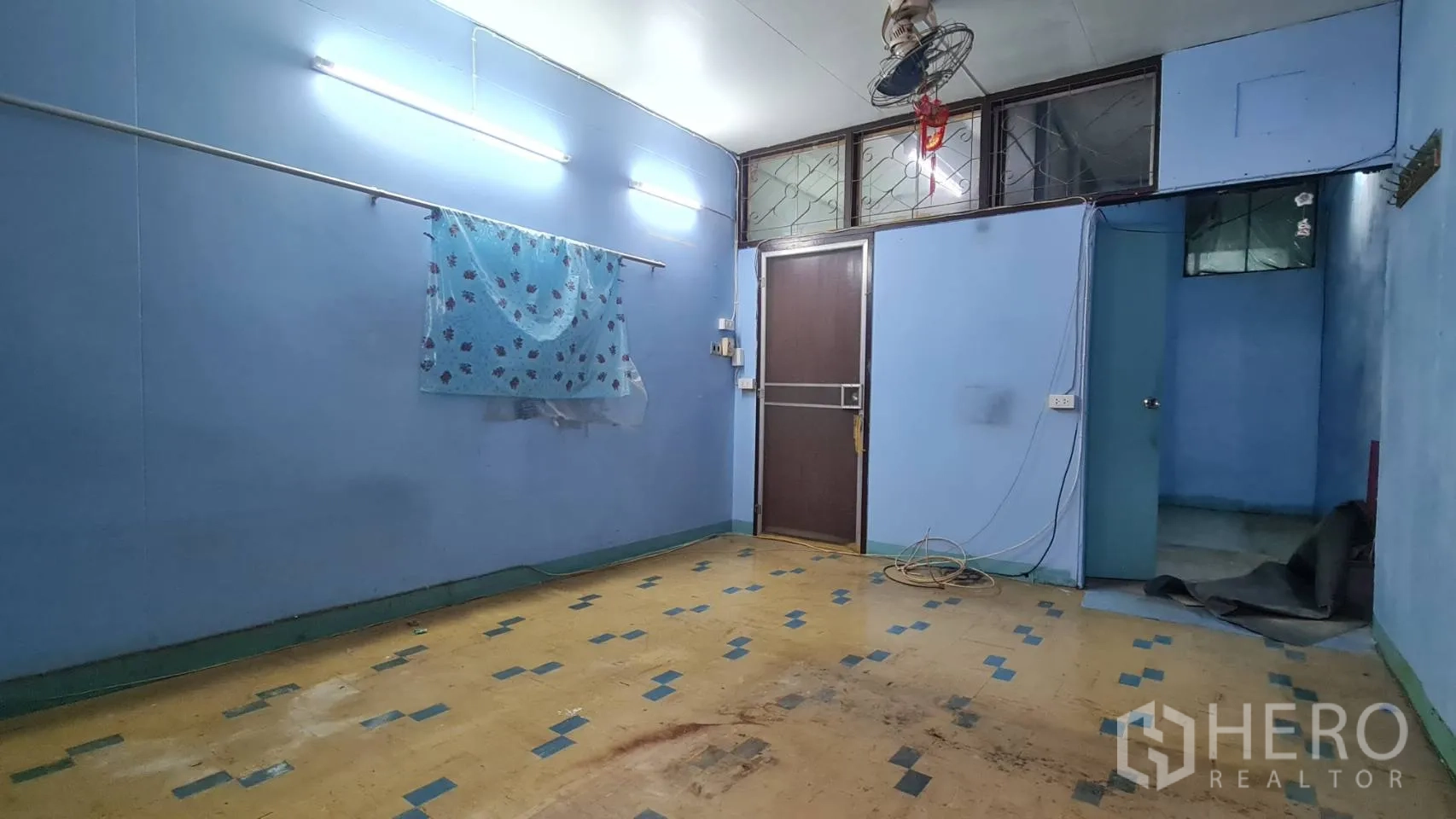 อาคารพาณิชย์ ให้เช่าหรือขายในWatthana, Bangkok - ห้องชั้นล่างผนังสีฟ้า ไฟนีออน พื้นลายกระเบื้องยาง และประตู