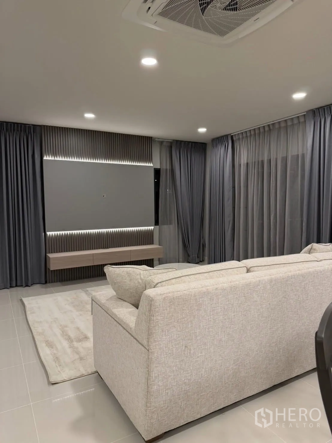 Detached House for rent in Bang Phli, Samut Prakan - TV feature wall with floating console and full-length curtains.