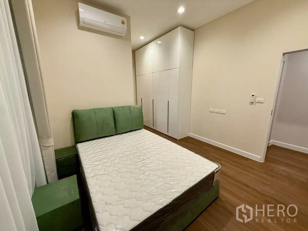 Detached House for rent in Bang Phli, Samut Prakan - Third bedroom with green headboard, wardrobe and wood flooring.