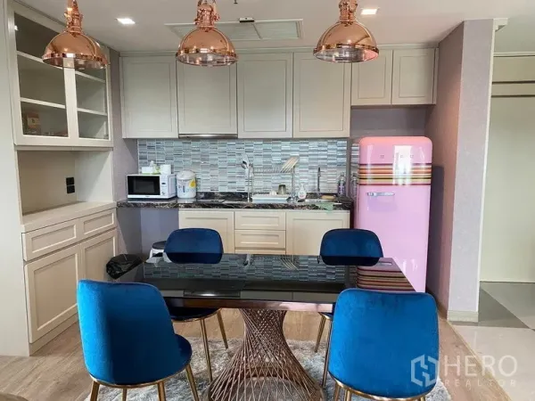 Condominium for sale in Bang Kho Laem, Bangkok - Modern kitchen with glass-tile backsplash, copper pendants and dining set.