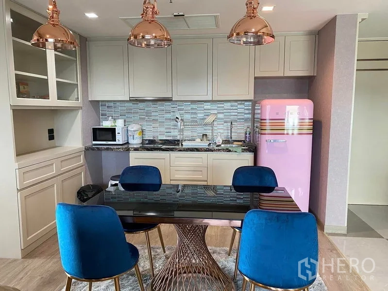 Condominium for sale in Bang Kho Laem, Bangkok - Modern kitchen with glass-tile backsplash, copper pendants and dining set.