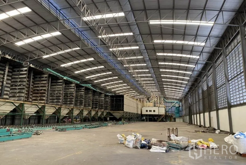 Factory for rent in Ban Phaeo, Samut Sakhon - Long-span warehouse hall with bright roof lighting and ventilation louvers along the side walls.