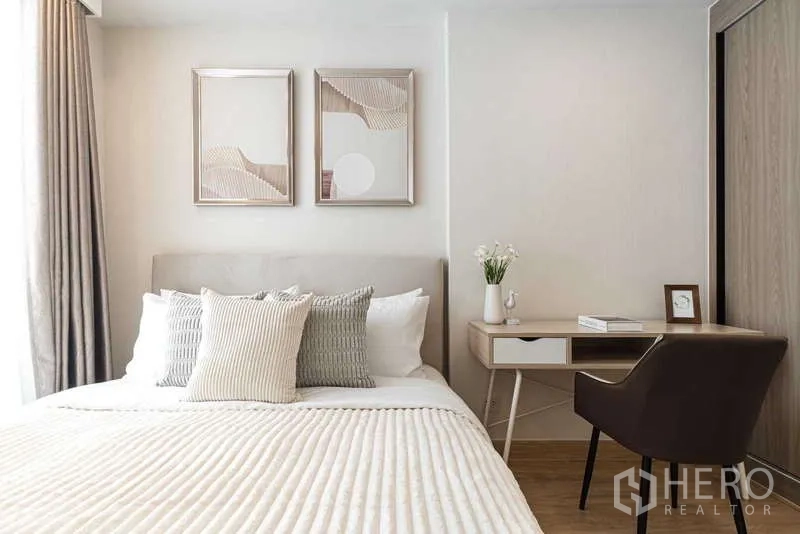 คอนโด ให้เช่า - ห้องนอนหลักพร้อมโต๊ะทำงาน งานศิลปะ และหัวเตียงบุผ้า