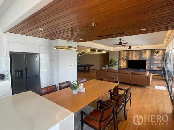 คอนโด ให้เช่าหรือขายในWatthana, Bangkok - ครัวและพื้นที่รับประทานอาหารแบบโอเพนพร้อมฝ้าไม้ ไอแลนด์ ตู้เย็นสีดำ และเชื่อมต่อห้องนั่งเล่น