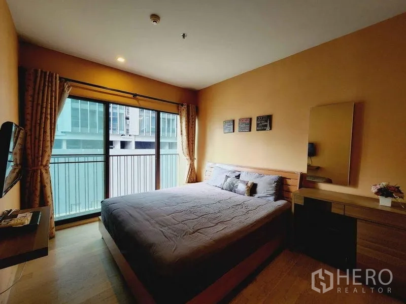 คอนโด ให้เช่าในBangkok - ห้องนอนใหญ่ เตียงคิงส์ โต๊ะเครื่องแป้ง และประตูกระจกสไลด์ออกระเบียง