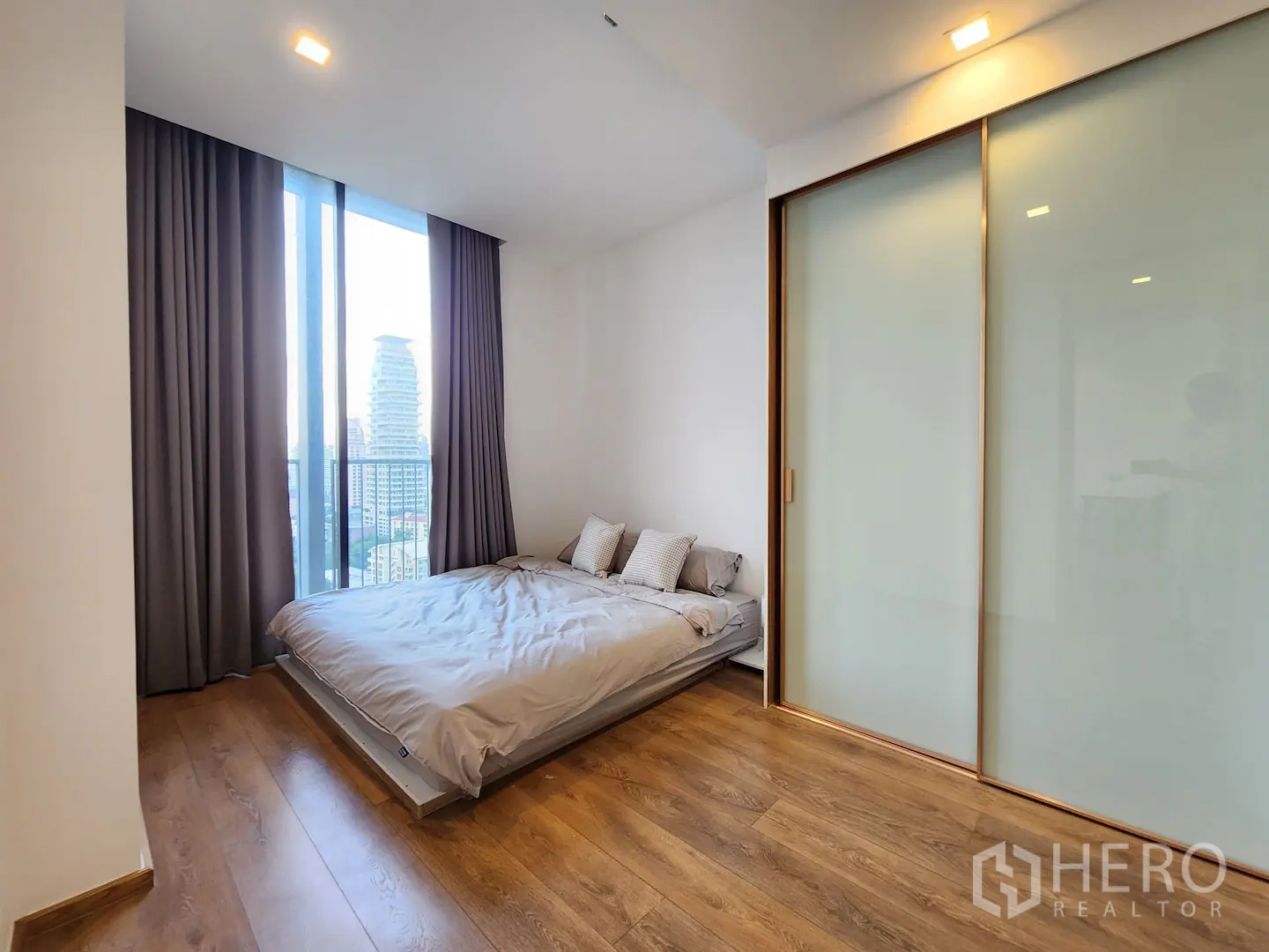 คอนโด for rent in Watthana, Bangkok - ห้องนอนพร้อมหน้าต่างสูงจรดเพดาน เห็นวิวเมืองและระเบียง ตู้เสื้อผ้าบานกระจกฝ้า
