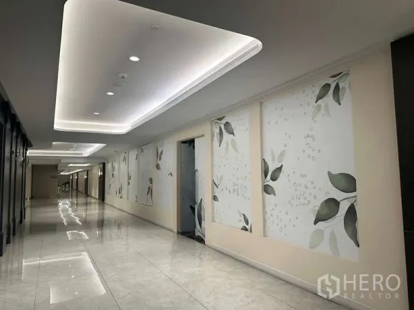 零售空间 出租 - 商场走廊已翻新，灯槽天花、大理石感地面与叶纹装饰墙。