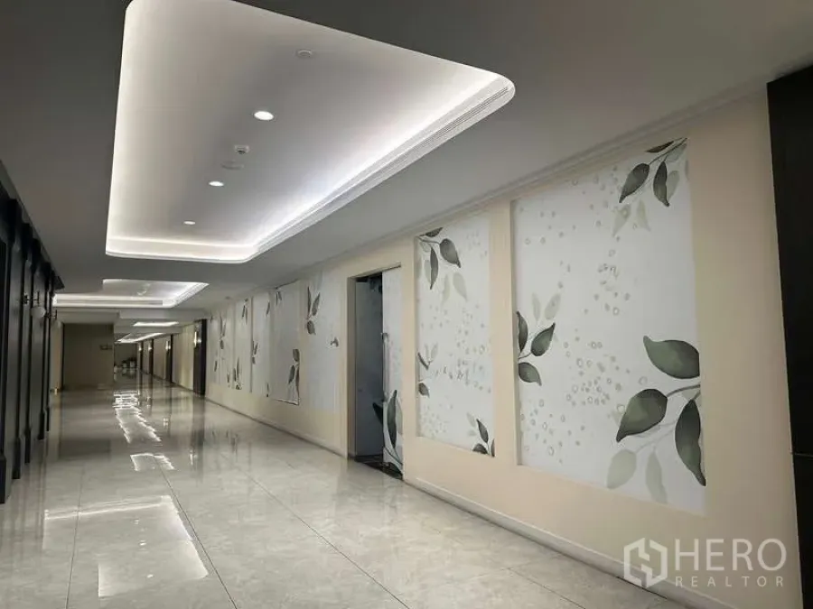 零售空间 出租 - 商场走廊已翻新，灯槽天花、大理石感地面与叶纹装饰墙。