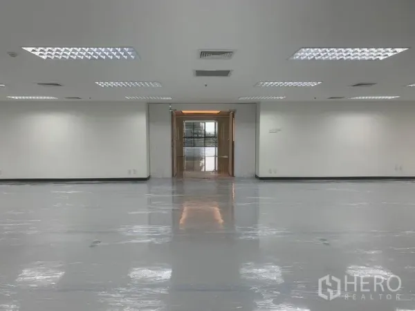 办公空间 出租在Bang Rak, Bangkok - 从办公区望向门厅的室内视角，顶面灯光通透明亮。